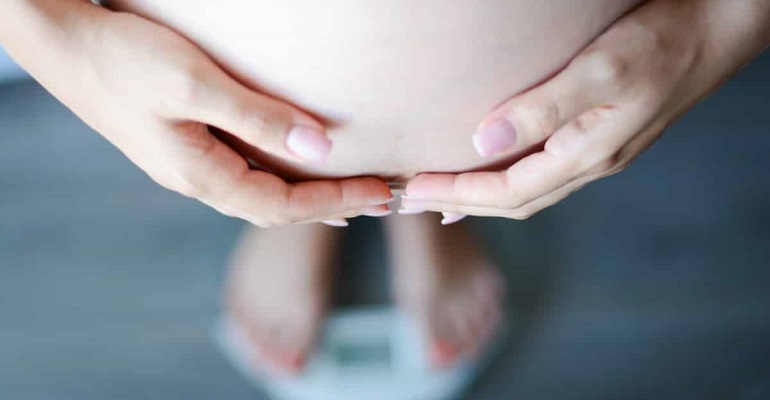 Беременная женщина на весах