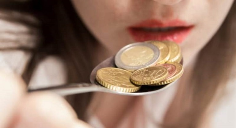 Женщина ест металлические монеты
