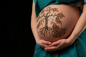 Рисунок хной на животе беременной