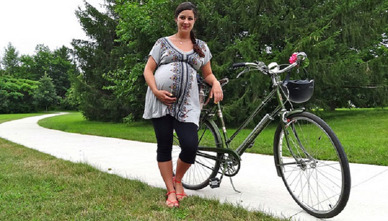 Беременная женщина с велосипедом