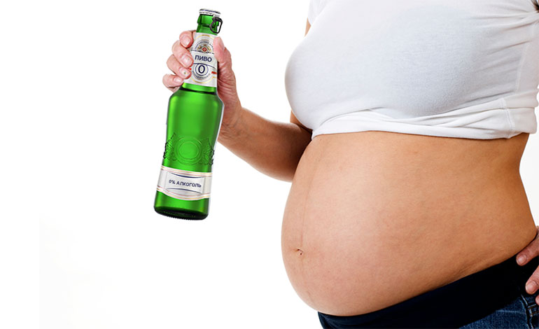 Беременная женщина с безалкогольным пивом
