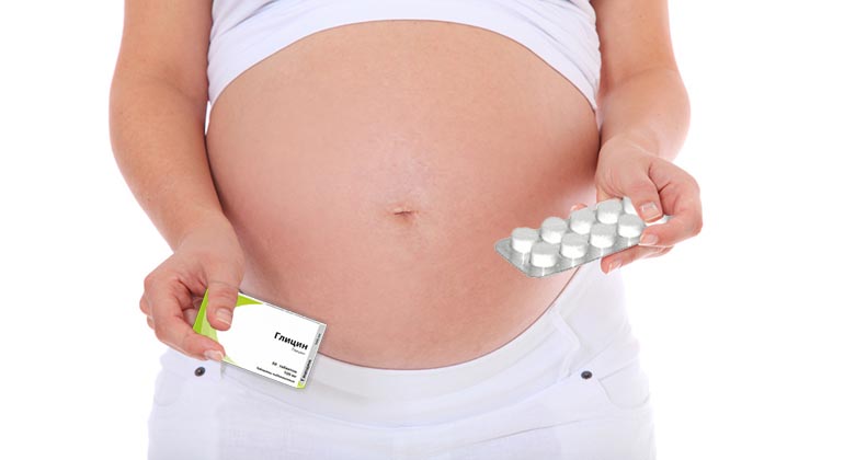 Беременная держит таблетки глицина